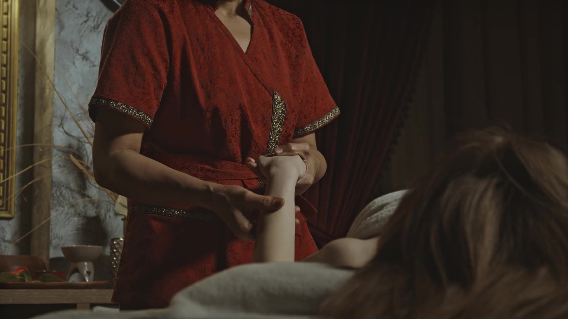 A spa therapist giving a hand and arm massage to a client in a softly lit treatment room